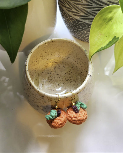 Small ceramic bowl with decorative elements on a light surface, surrounded by green leaves.