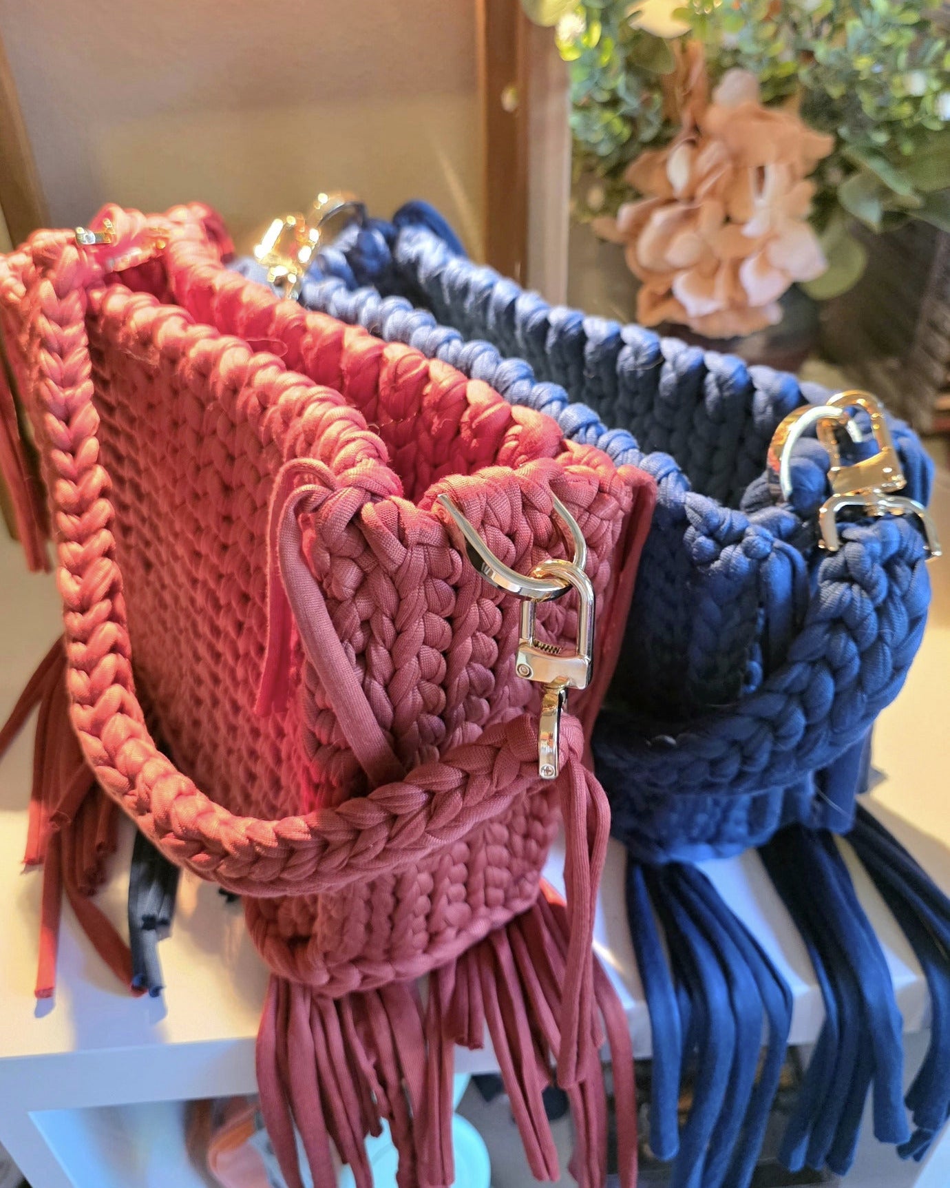 Two crochet bags, one red and one navy in a close up shot of the stitches