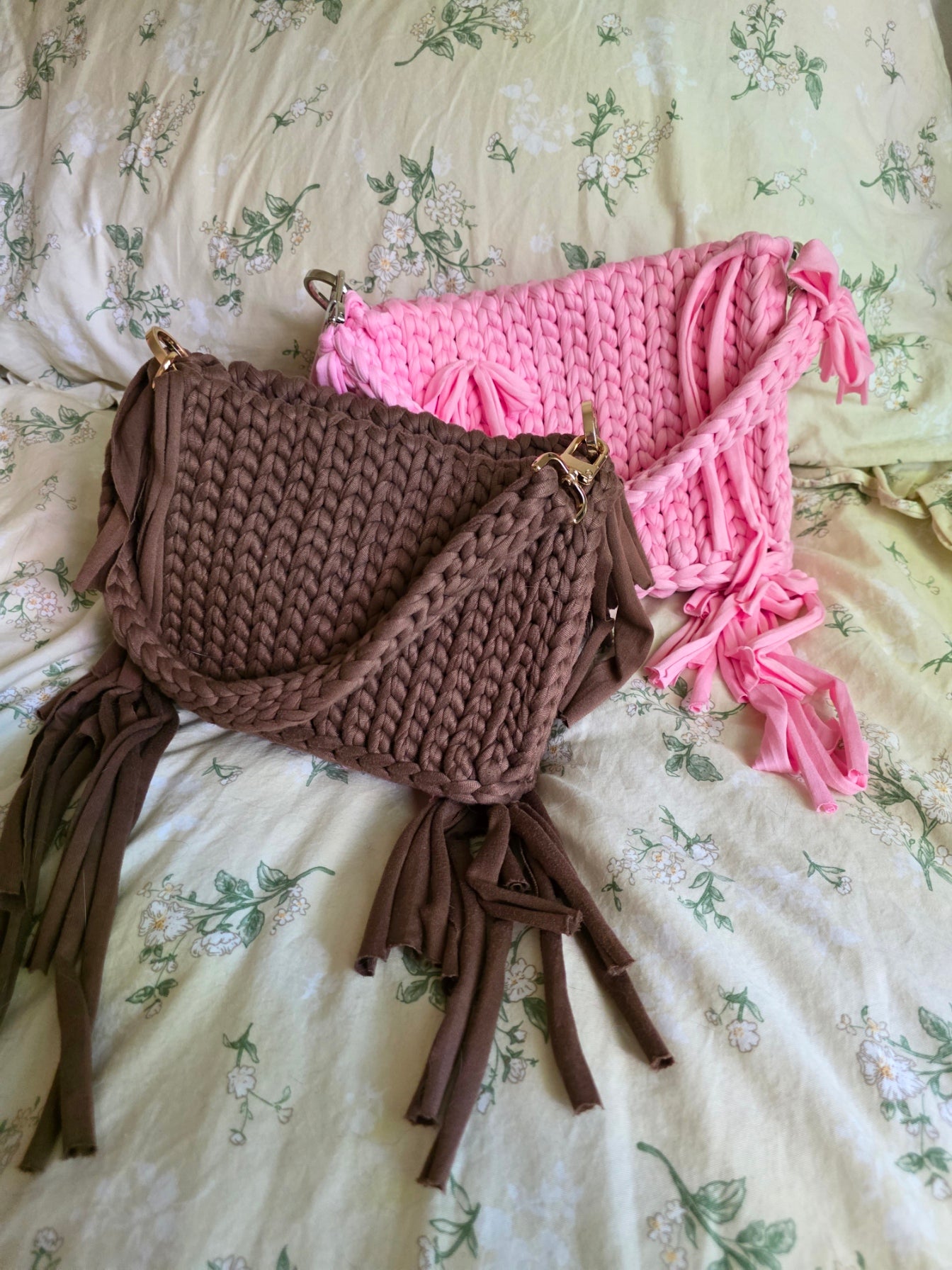 Crocheted pink and brown headbands on a floral-patterned fabric background